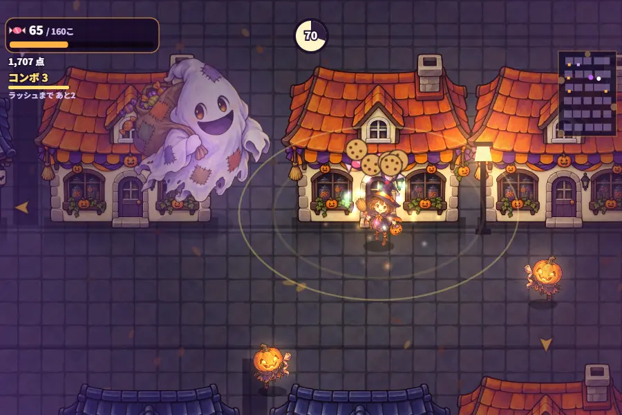 夜の町を見下ろしたゲーム画面。玄関灯が光る家の前で魔女の仮装の女の子がノックし、ドアからクッキーが飛び出している。左にお菓子袋をかついだ大きなおばけ、右と下からカボチャ頭のいたずらっ子が近づいている