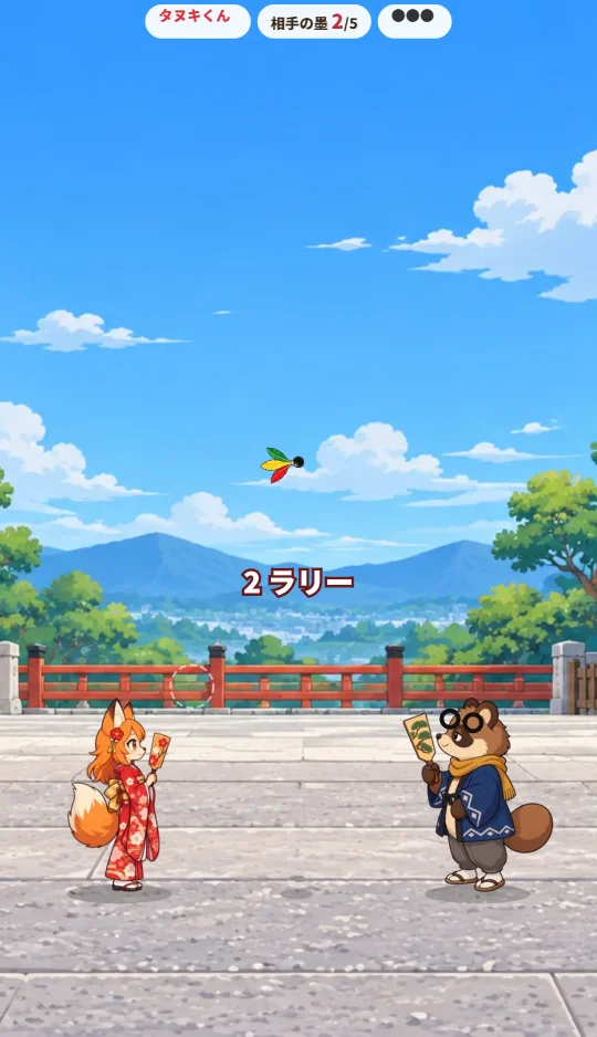 スマホの縦画面で、神社の境内の左にキツネの女の子、右にタヌキの子、あいだを羽根が飛んでいる場面
