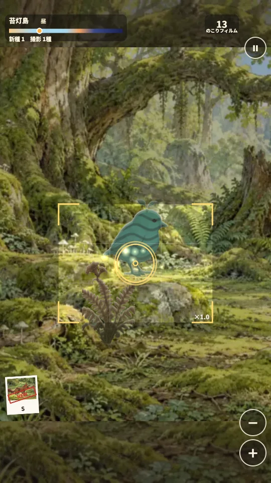 スマホの縦画面。苔むした森の岩の上に、しま模様の青緑色の小鳥が現れ、ファインダーの中で金色のピントの輪が合っている。上に島の名前と時間の帯、のこりフィルム、左下にとったばかりの写真、右下にズームのボタン