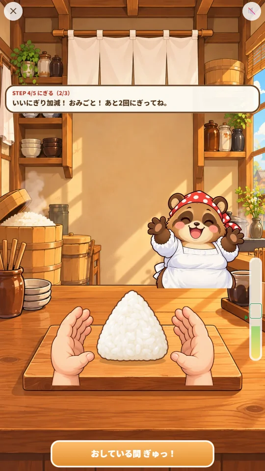 スマホの縦画面で、まな板の上の白い三角おにぎりを左右の手ではさんでにぎり、右はしのメーターに白いわくがあり、奥でたぬきのかあさんが両手をあげてよろこんでいる