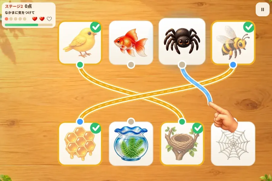 ゲーム画面。木の机の上に白い紙のカードが左右2列にならび、それぞれに動物や道具の絵がかかれている。カードとカードのあいだに、指でひいた色つきの線が何本かつながっている